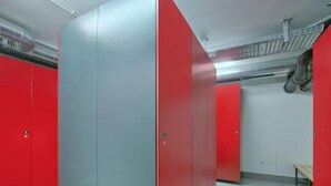 A room with red and grey lockers, a bench, and a tiled floor. - Top-floor Mountain Penthouse for 8 (Neukirchen am Grossvenediger)