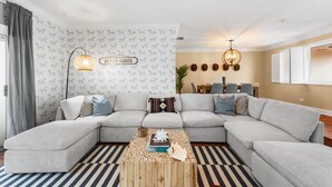 A modern living room with a sectional sofa, a coffee table, and decorative wall art.