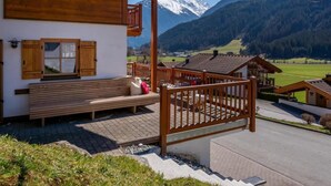 A wooden bench outside a building with a view of snow-capped mountains. - Comfortable Alpine Chalet for 12 (Wald im Pinzgau)