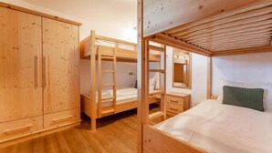 A wooden bunk bed room with a wardrobe and a small bedside table. - Comfortable Alpine Chalet for 12 (Wald im Pinzgau)