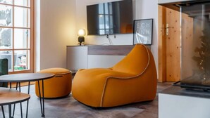 A modern living space with a sofa, ottoman, and a small table. - Comfortable Alpine Chalet for 12 (Wald im Pinzgau)