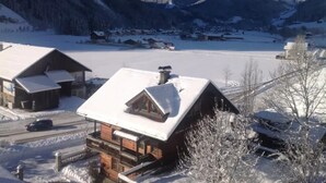 A snow-covered mountain village with wooden houses and a clear view of the mountains. - Schoneben Mountain Holiday Home (Wald im Pinzgau)