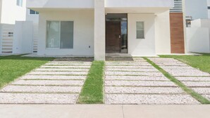 A modern two-story house with a flat roof, large windows, and a visible garage door. - Family Home Near the Beach in Velamar (Altamira)