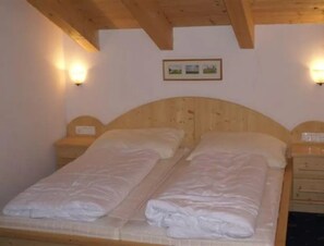 A double bed with wooden headboard and two bedside tables, each with a lamp. - Sunlit Alpine Chalet Stay (Wald im Pinzgau)