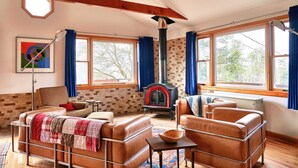 A cozy living room with a fireplace, leather sofas, and large windows. - Meadow House at Seminary Hill by Avantstay (Callicoon)