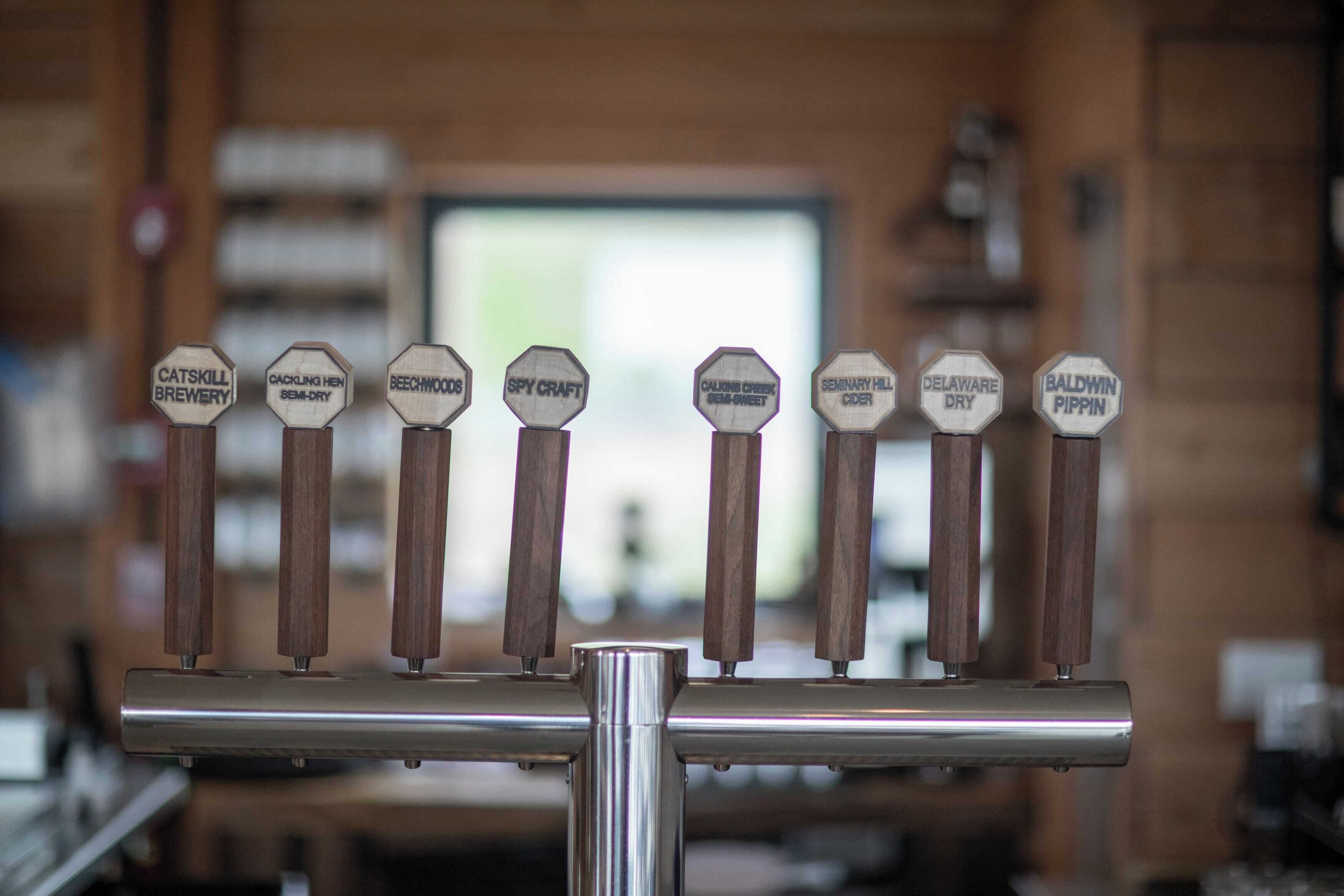 A row of beer taps with labels for different types of beer.