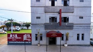 A hotel with a tiled facade, a red awning, and a signboard advertising the Carlton Imbira Express hotel. - Hotel Carlton Imbiara Express (Araxá)