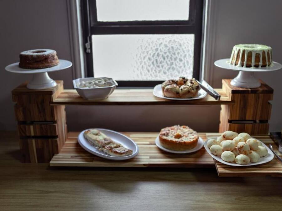 Una mesa de madera con varios postres y una ventana al fondo.