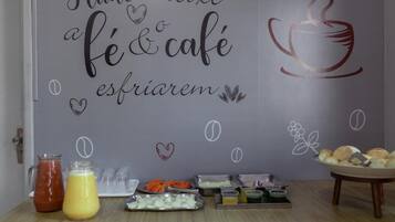 A breakfast setup with a wall mural, a fruit platter, and various food items.