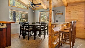 A wooden interior with a dining table, chairs, and a ceiling fan. - Enchanting Escape | Hot Tub, Fire Pit & Game Room (Big Bear Lake)