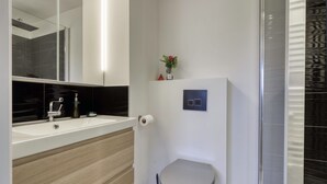 A modern bathroom with a sink, toilet, and shower. - L'Estran - Appt 2p, proche de la mer (Villers-sur-Mer)