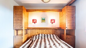 A room with a wooden headboard, a fur-covered bed, and two wall-mounted lamps.