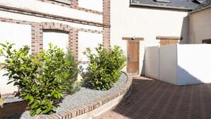 Un edificio con fachada de ladrillo, puerta de madera y pared blanca.