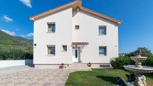 A two-story building with a central entrance, a paved driveway, and a well-maintained lawn. - Four Bedroom Holiday Home with Pool (Kastel Stari)