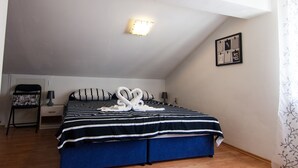 A bedroom with a bed, a nightstand, a lamp, a wall-mounted light, and a framed picture. - Four Bedroom Holiday Home (Rijeka)