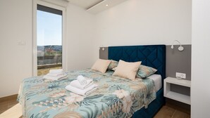 Une chambre à coucher avec un lit, une table de chevet et une vue sur l’extérieur.