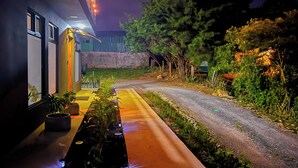 A pathway leading to a building with a covered outdoor seating area and potted plants. - Monstera Apartments Monteverde (Monteverde)