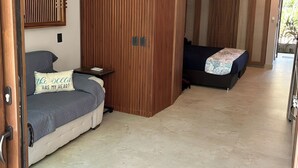 A modern bedroom with a bed, a desk, and a wardrobe. - Charming Ocean line studio with largest pool in beautiful Troncones (Troncones)