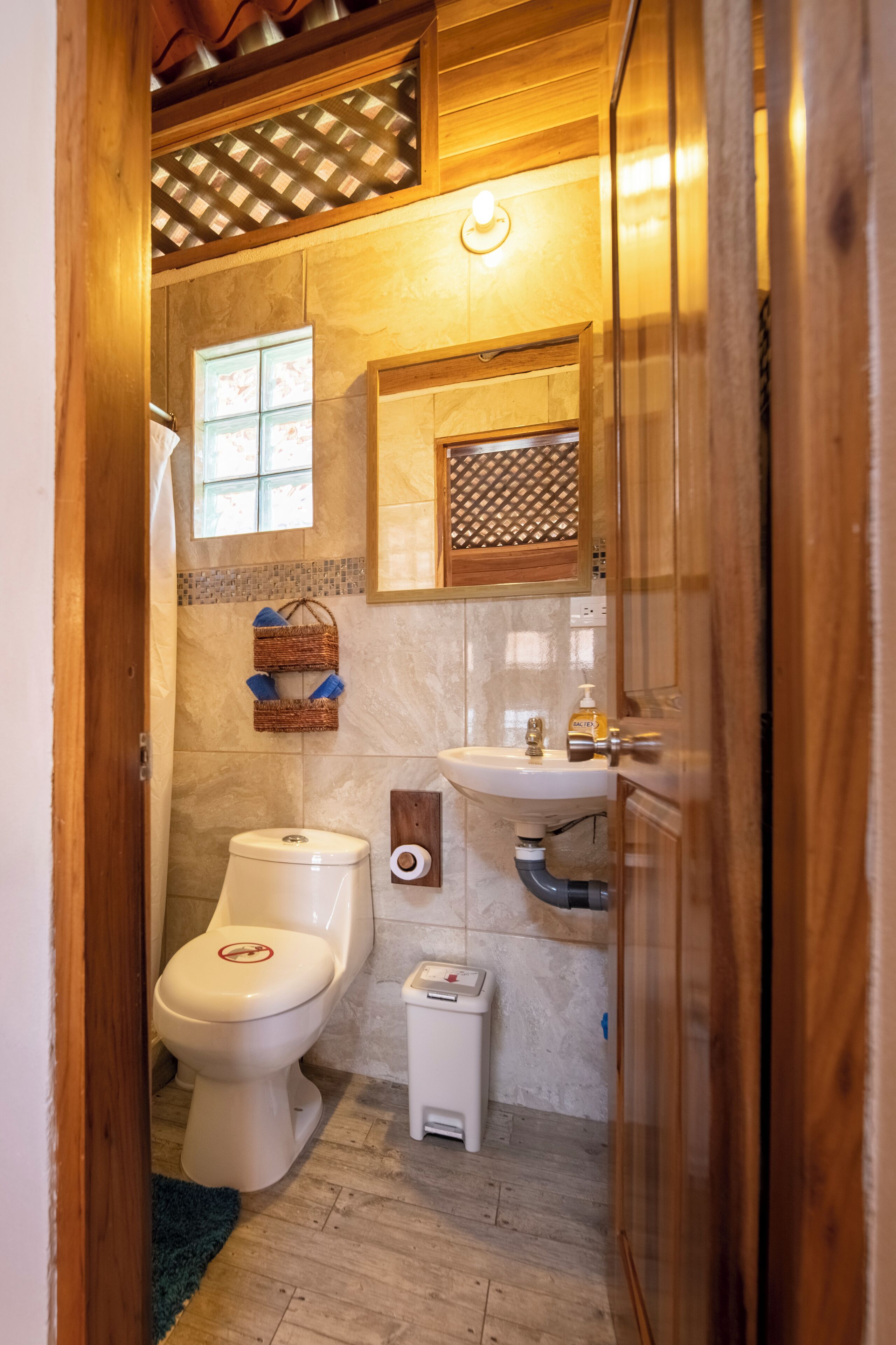 A compact bathroom with a toilet, sink, and a small window.