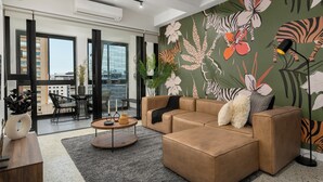 Una sala de estar moderna con un sofá modular, una mesa de centro y un vibrante mural floral en la pared.