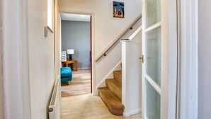 A hallway with a staircase leading to a room.