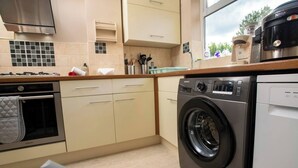 A compact kitchen with a built-in washer and dryer, a microwave, and a stove.