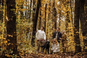 Un grupo de personas en un bosque lleno de hojas otoñales.