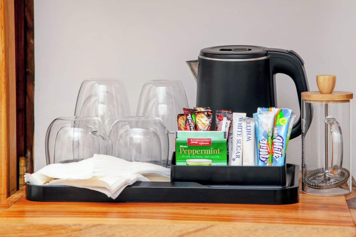 Una caixa forta amb una cafetera, sobres de te i gots sobre un taulell de fusta.