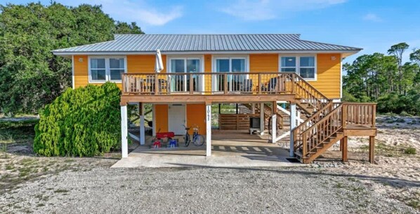 A two-story building with a balcony, a covered porch, and a staircase. - Honey Hole on St George Island Pet Friendly Private Pool (Heated for a fee) West Gulf beaches (Saint George Island)