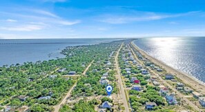 An aerial view of a coastal residential area with houses, a beach, and a clear sky. - Honey Hole on St George Island Pet Friendly Private Pool (Heated for a fee) West Gulf beaches (Saint George Island)