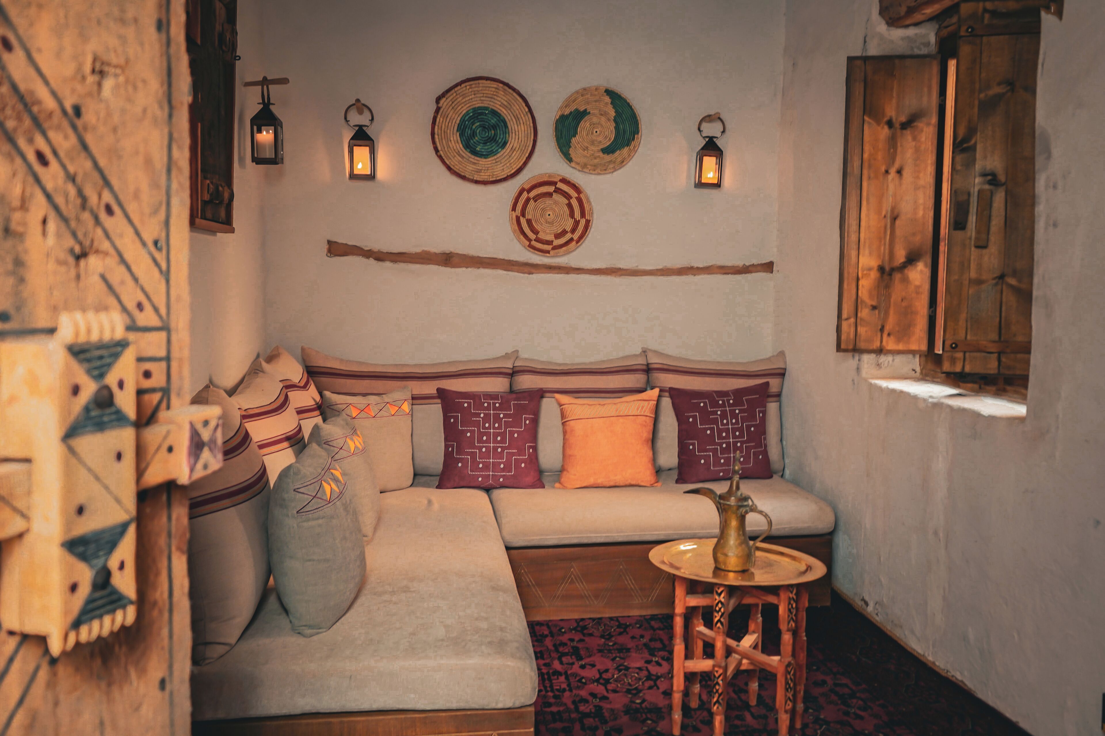 A cozy room with a sofa, pillows, a small table, and wall decorations.