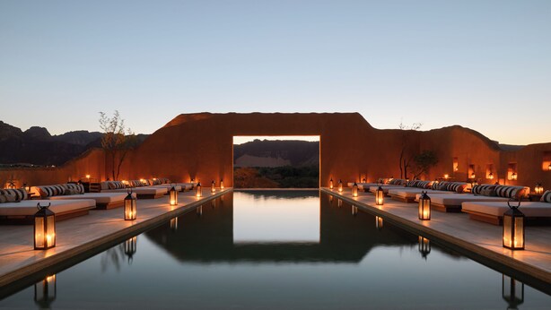 A serene pool area with seating and lanterns, surrounded by a mountainous landscape. - Dar Tantora The House Hotel (Al-'Ula)