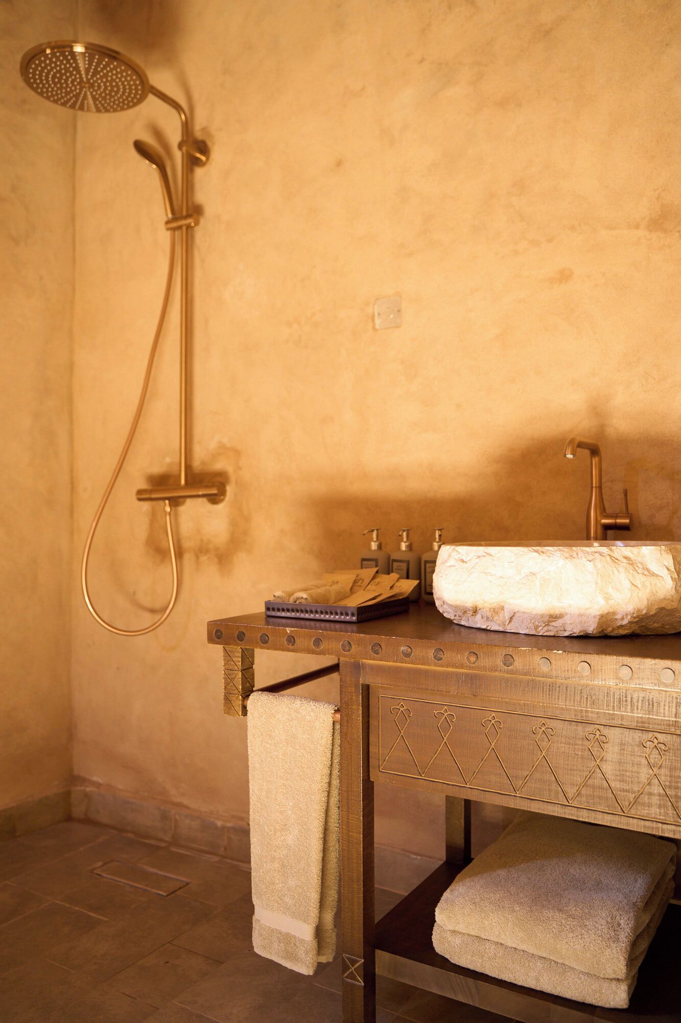 A bathroom with a shower, a sink, and a towel rack.