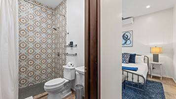 A bathroom with a shower, toilet, and sink.
