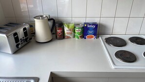 A kitchen counter with a toaster, a kettle, a coffee maker, a can of Miso soup, a box of tea bags, and a box of sugar. - LUXURY 4 BEDROOM KING BED SPA ARCADE WIFI NETFLIX SLEEPS 10 WITH BOAT PARKING (Portland)