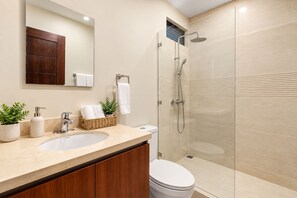 A modern bathroom with a sink, mirror, and shower.