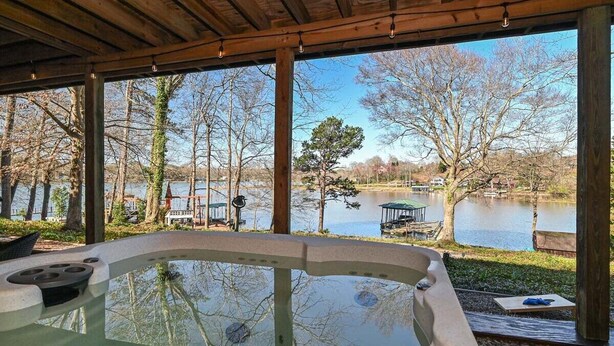 A hot tub with a view of a lake and trees.