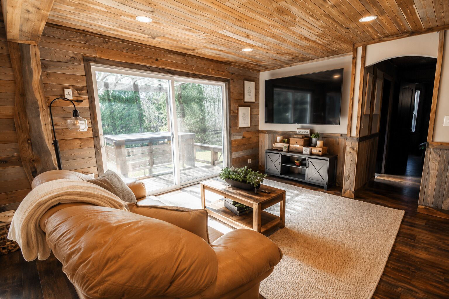 A cozy living room with a sofa, a coffee table, and a TV.