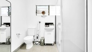 A modern bathroom with a toilet, sink, and mirror.