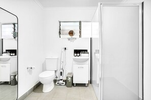 Et moderne badeværelse med toilet, vask og spejl.