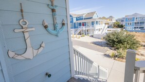A coastal building with a porch decorated with nautical anchors. - Oceanside 7min walk2beach,6BR,Pool,HotTub,Foosball (Corolla)