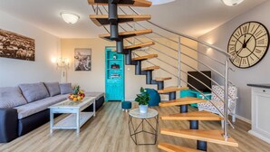 A modern living room with a spiral staircase, a sofa, a coffee table, and a clock on the wall. - Villa Leticia Crikvenica Riviera (Hreljin)