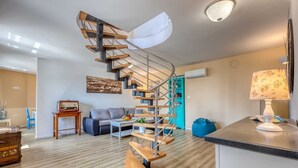 A modern living room with a spiral staircase, a sofa, a coffee table, and a lamp. - Villa Leticia Crikvenica Riviera (Hreljin)