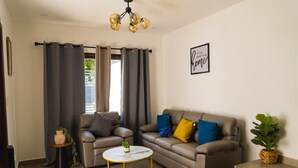 A living room with a sofa, a coffee table, and a potted plant. - Casa SOFIA, spacious, safe, easy access, pets welcome  (Santa Rosa de Copán)