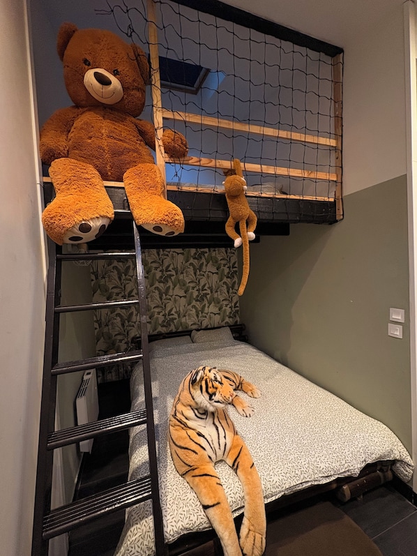 A bunk bed with a teddy bear and a toy monkey on the top bunk, and a plush tiger on the bottom bunk.