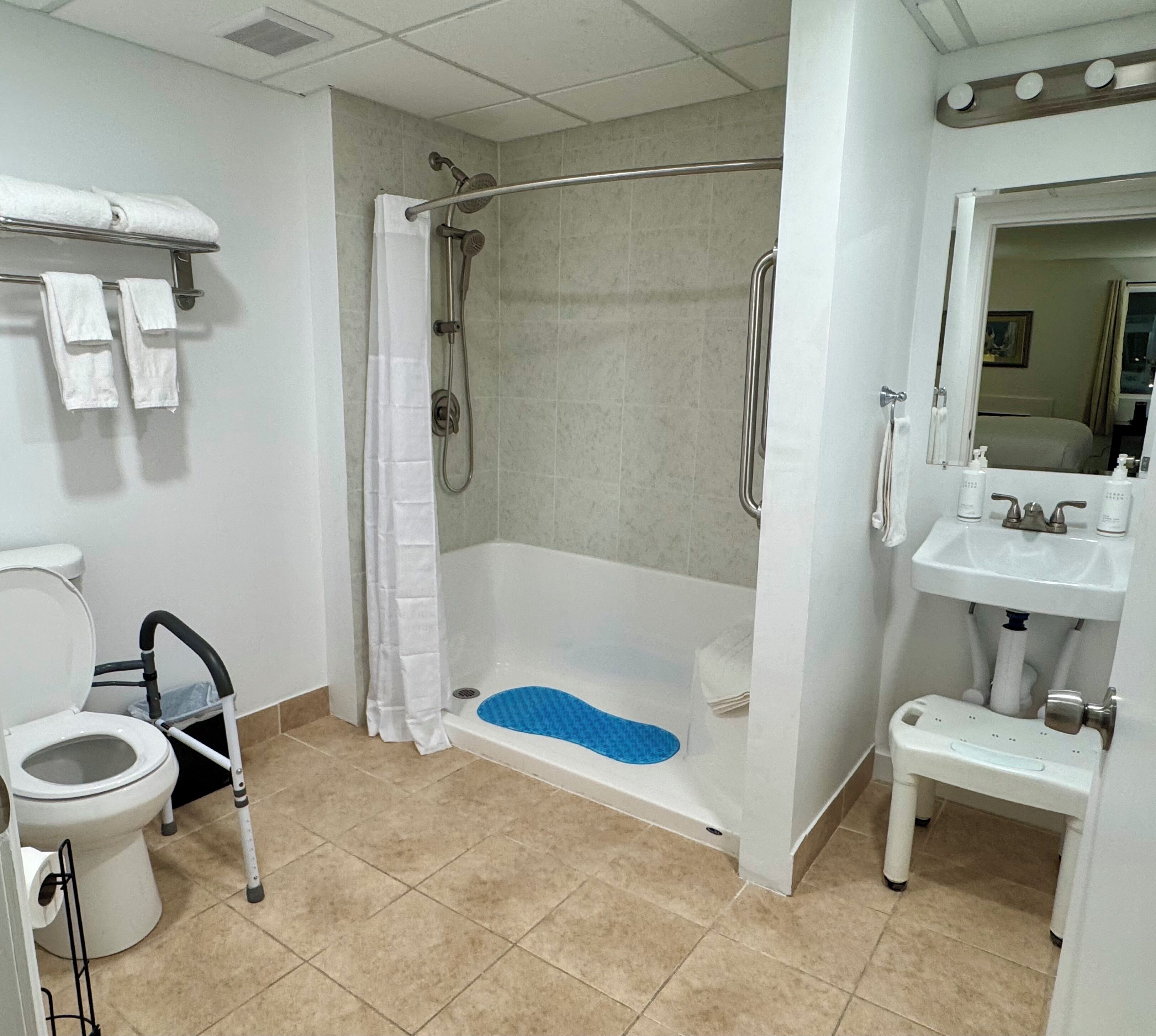 Een badkamer met douche, toilet en wastafel.