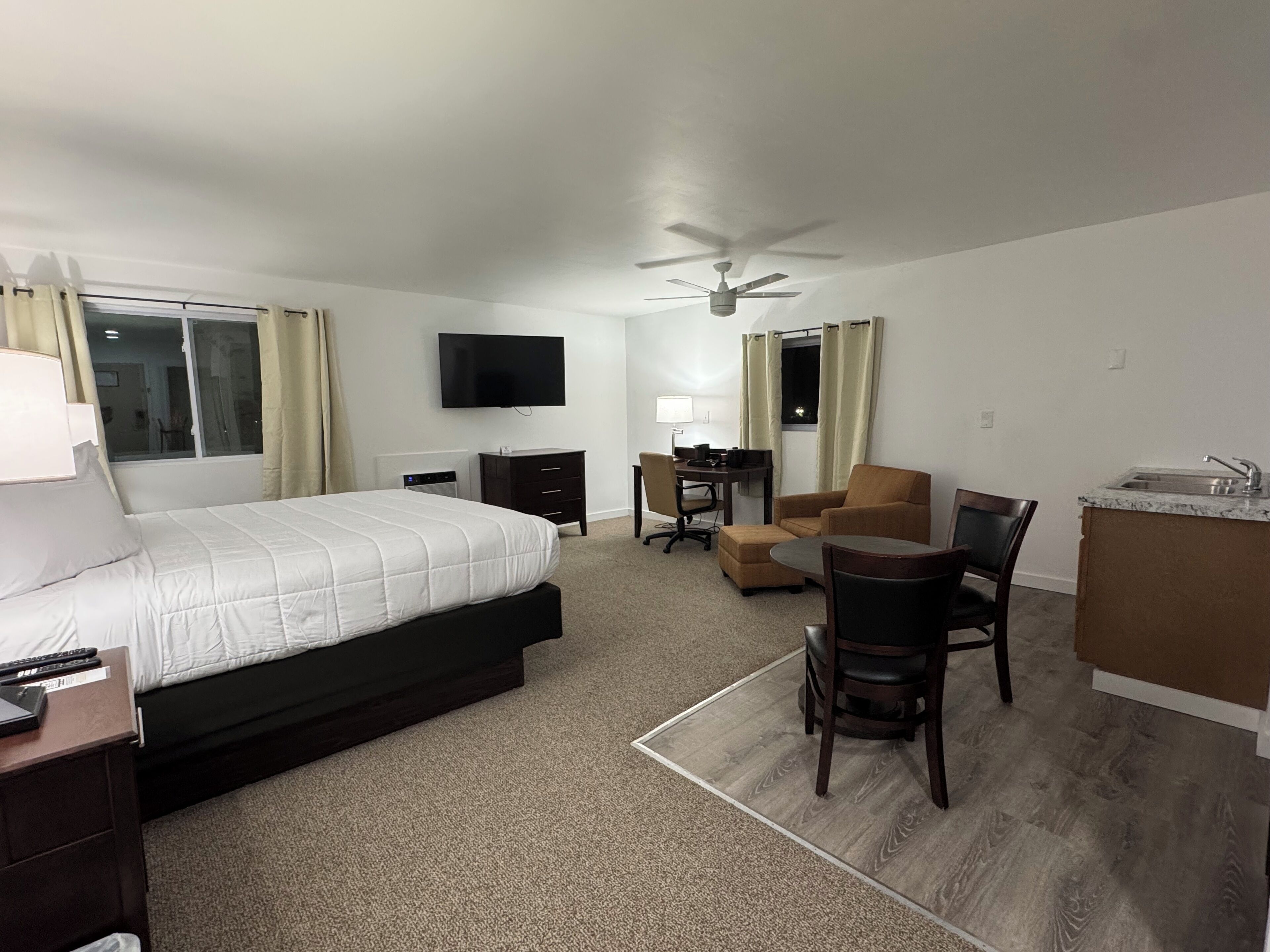 Une chambre d’hôtel équipée d’un lit, d’un bureau, d’une chaise et d’une kitchenette.