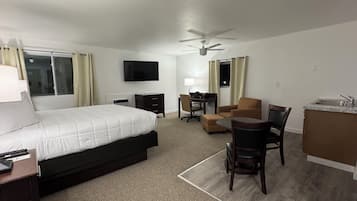 Une chambre d’hôtel équipée d’un lit, d’un bureau, d’une chaise et d’une kitchenette.