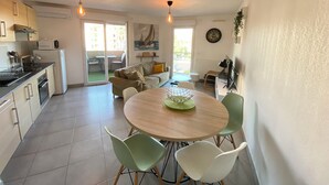 Une cuisine compacte avec un coin repas, un canapé et un téléviseur.
