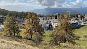 A town with buildings, a bridge, and mountains in the background.